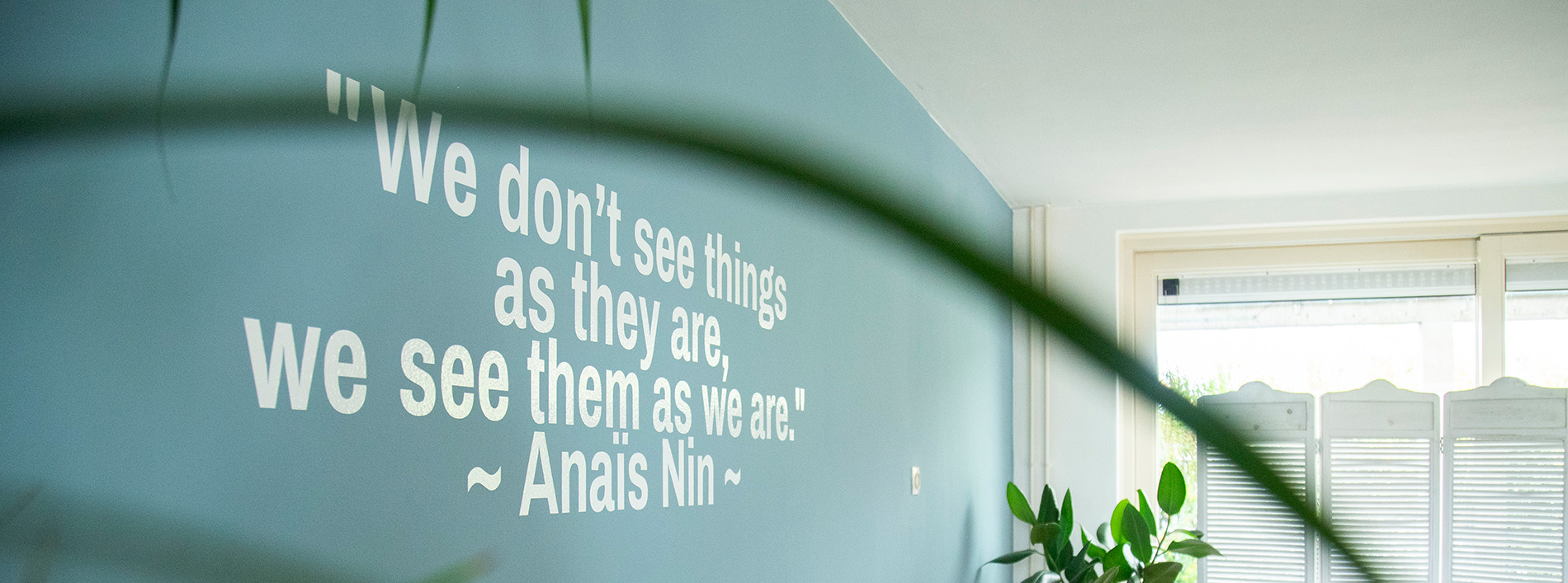 close-up van muur met spreuk: We don't see things as they are, we see them as we are